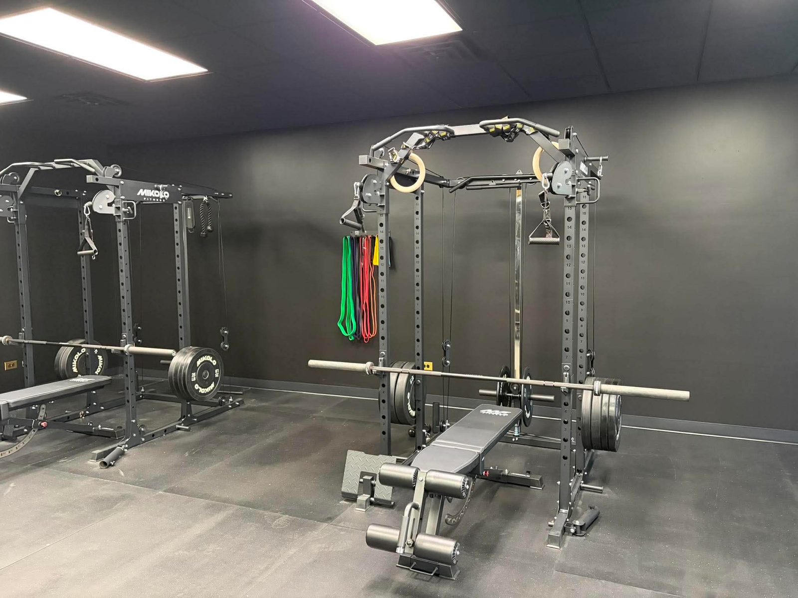 Rack, barbell, and resistance bands inside the Odyssey Strength & Recovery training facility in Joliet, IL